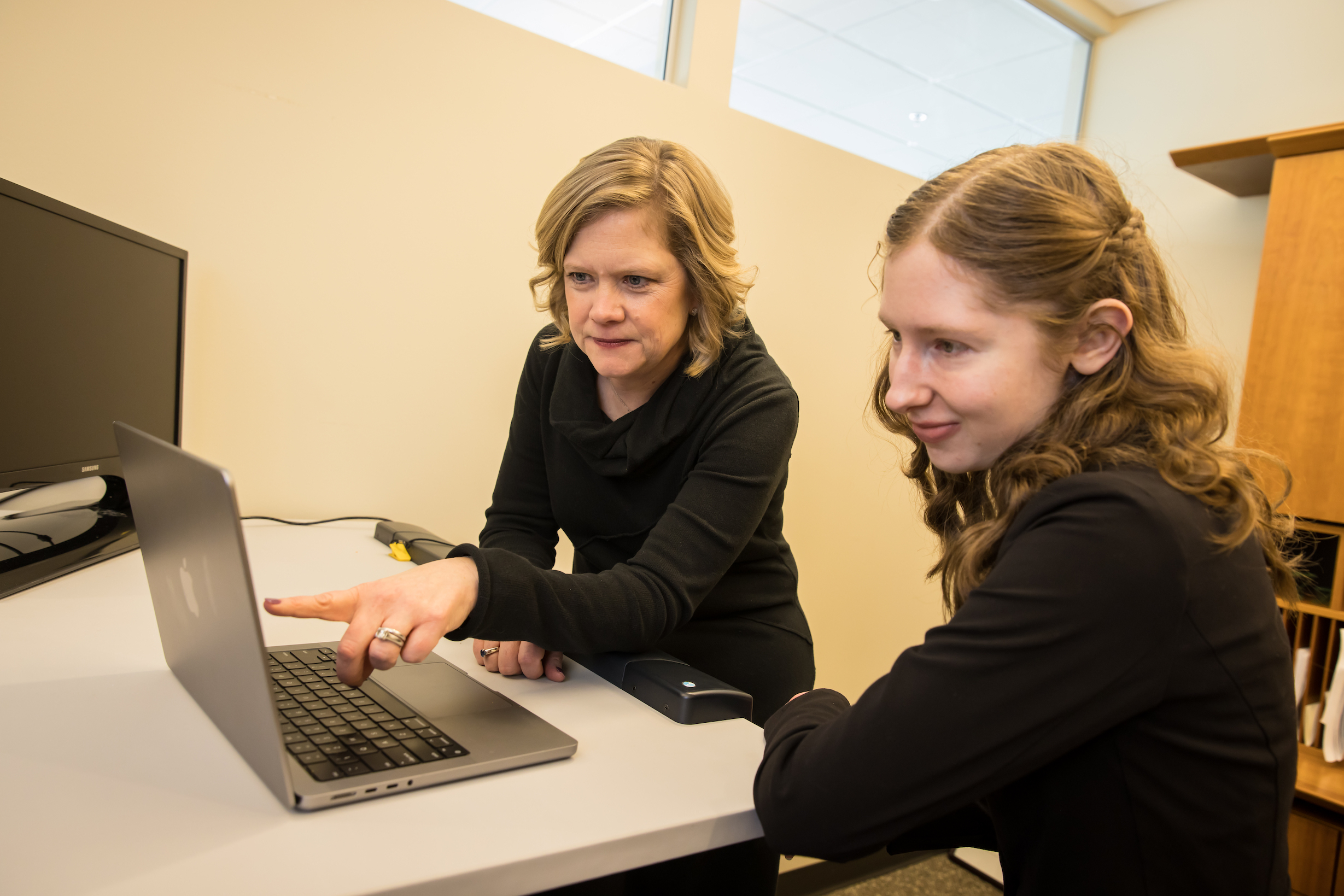 Angie Fagerlin, PhD, and graduate student Holly Shoemaker analyzing data at the computer.