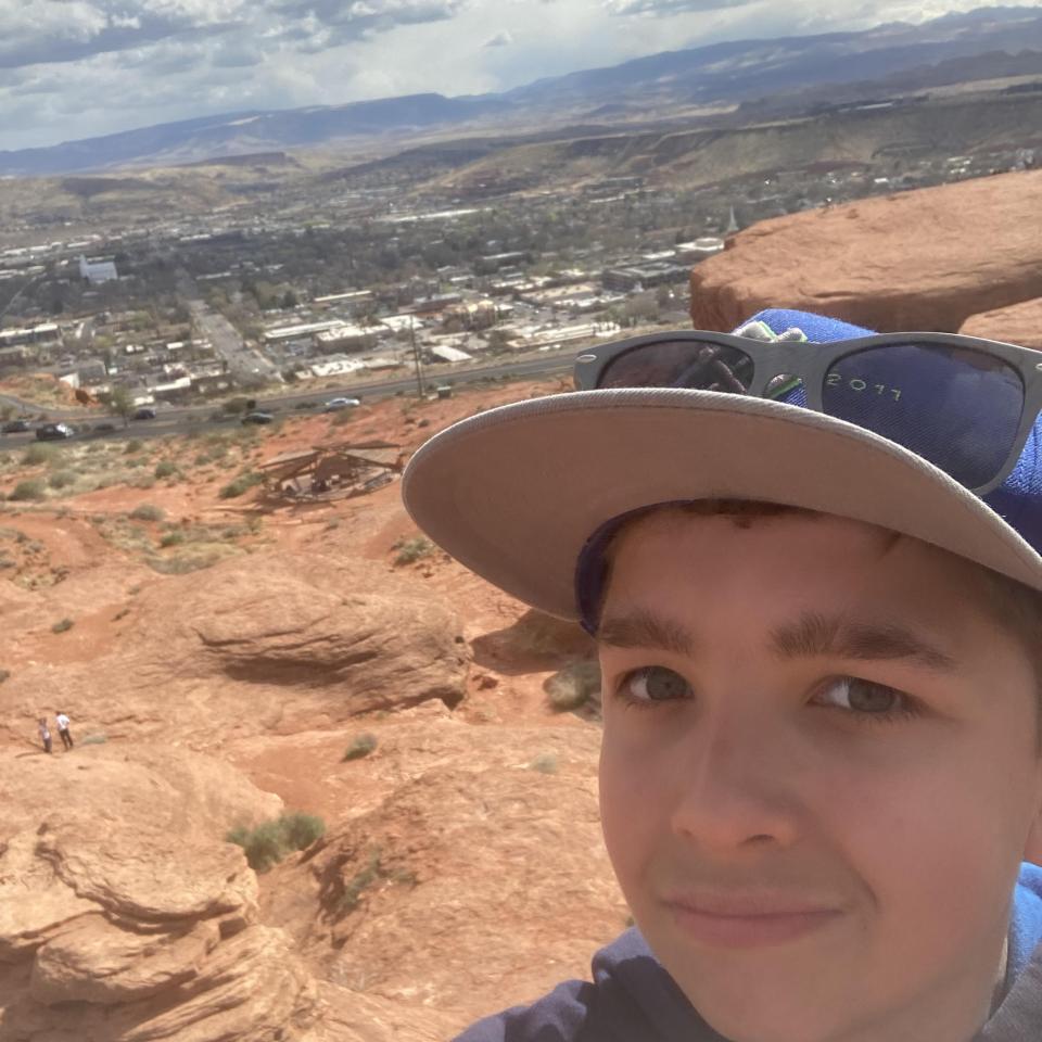 Young boy takes a selfie while on a red rock hike