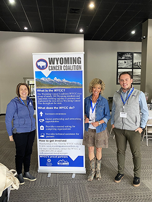 three people standing next to a sign with facts about wyoming on it