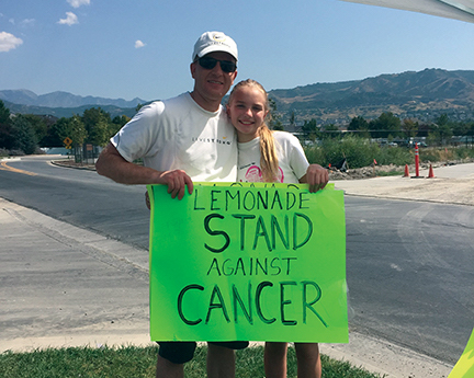 Adalyn Wood and her dad raise money for cancer research at their lemonade and cookie stand.