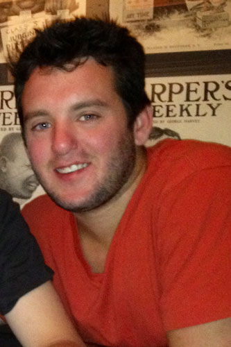Adam Singer smiling at the camera at a restaurant