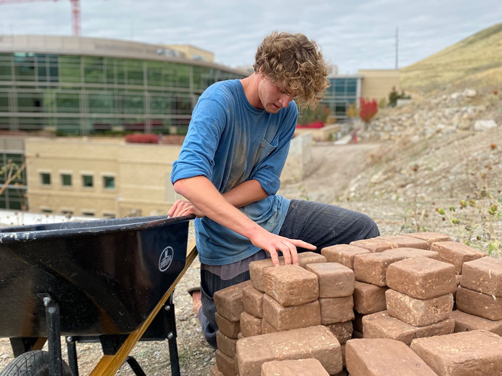 Griffin Hale building his art installation on the hill behind Huntsman Cancer Institute