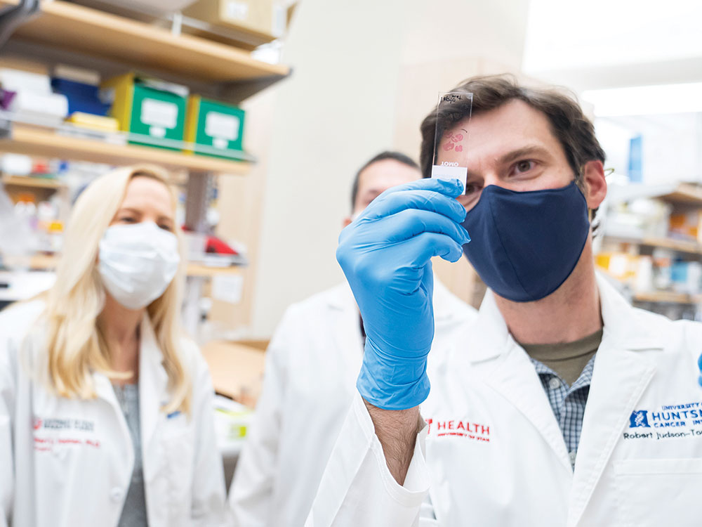 Robert Judson-Torres, PhD examines slices of melanocytic tumors with research colleagues at Huntsman Cancer Institute.