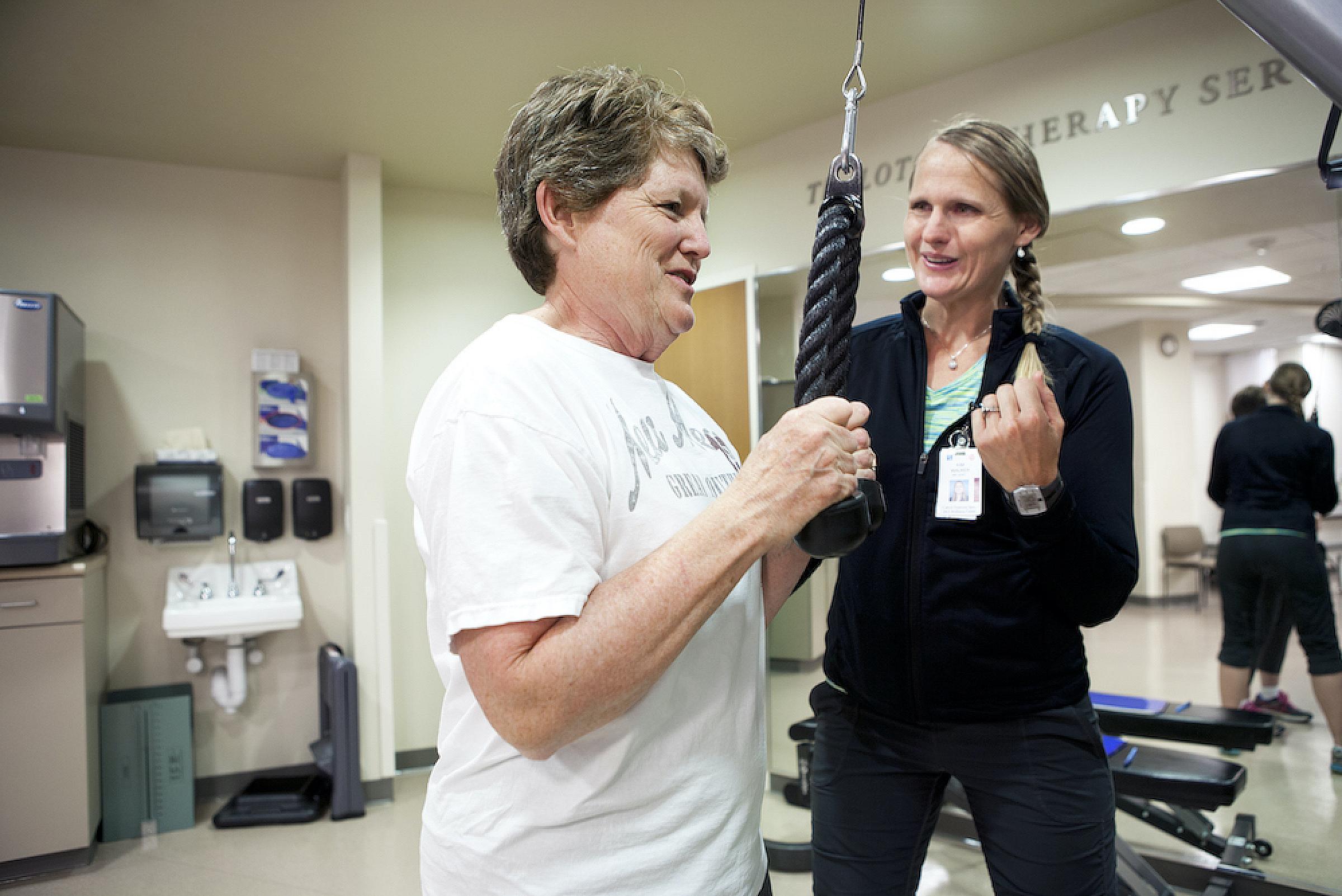 Provider assists patient while doing physical therapy exercises