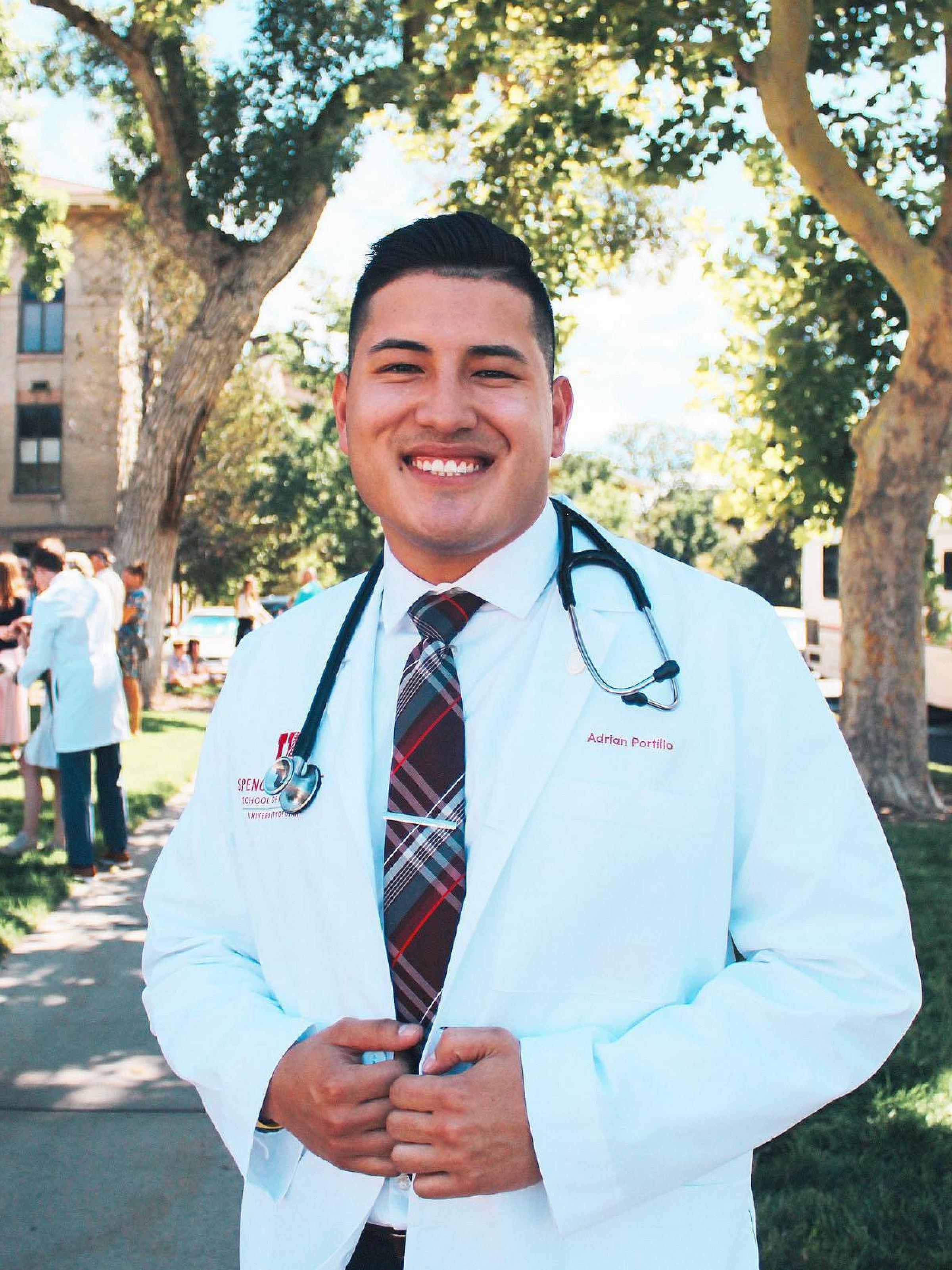 Adrian Portillo wearing lab coat and stethoscope at outdoor event