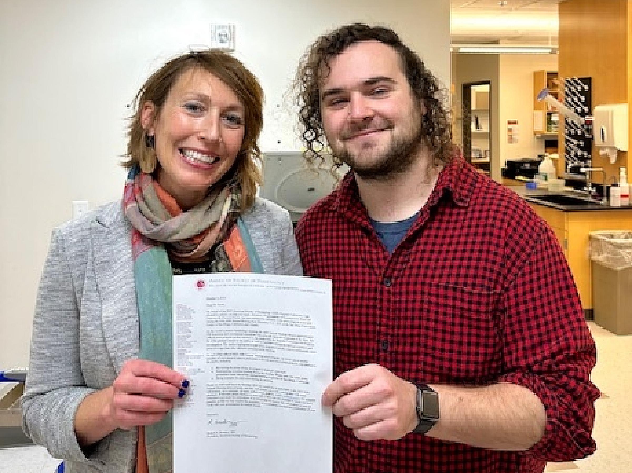 Anna Beaudin, PhD, and Brian Krum holding ASH acceptance letter