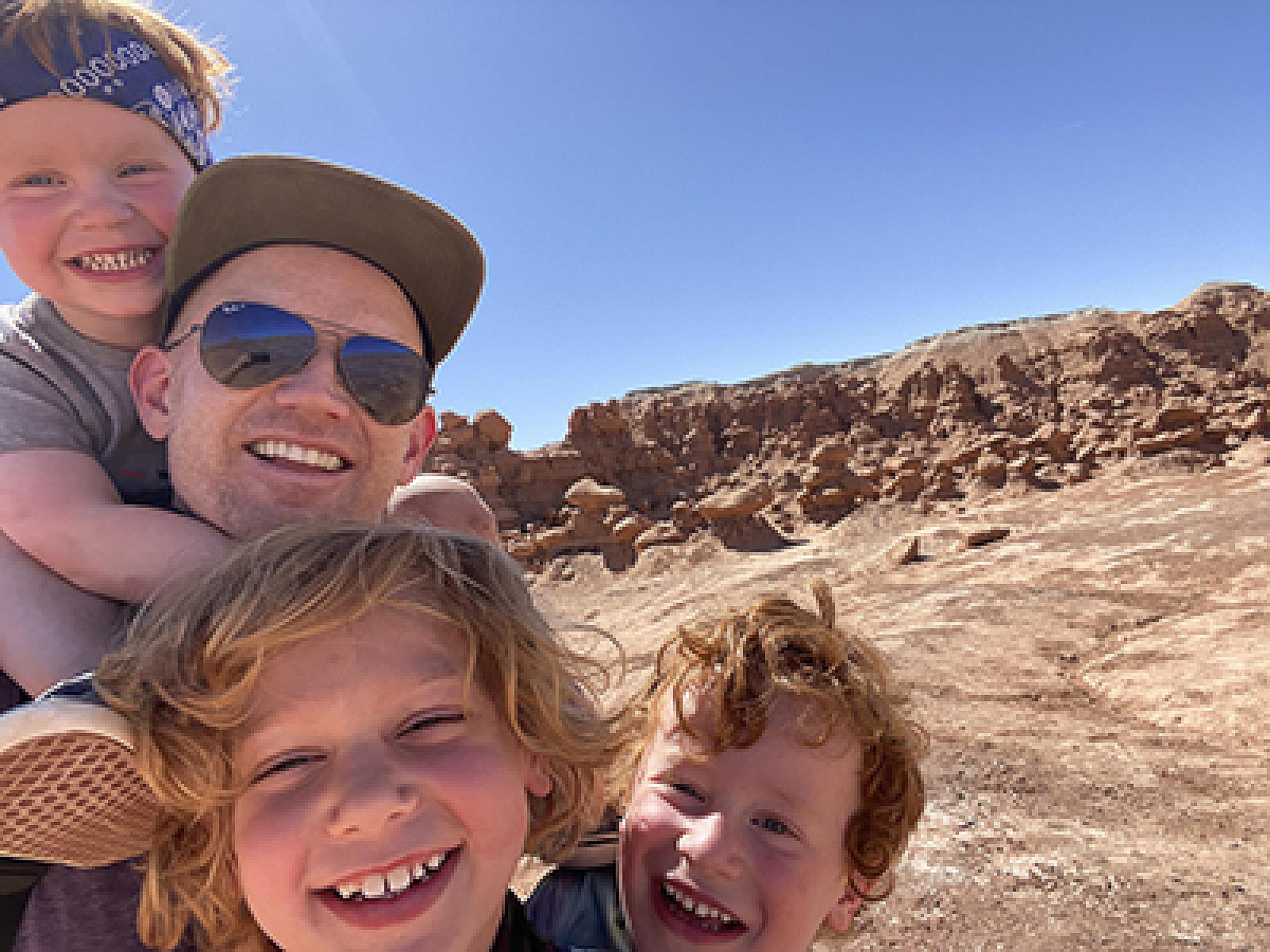 Brandon Plewe and three of his sons posing with red rock formations behind them