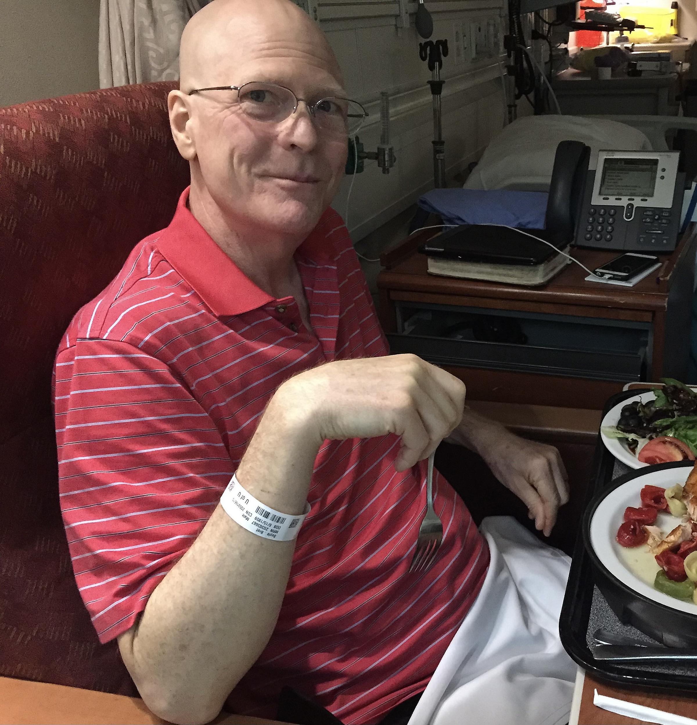 Bret Boyle sitting in a hospital room eating dinner