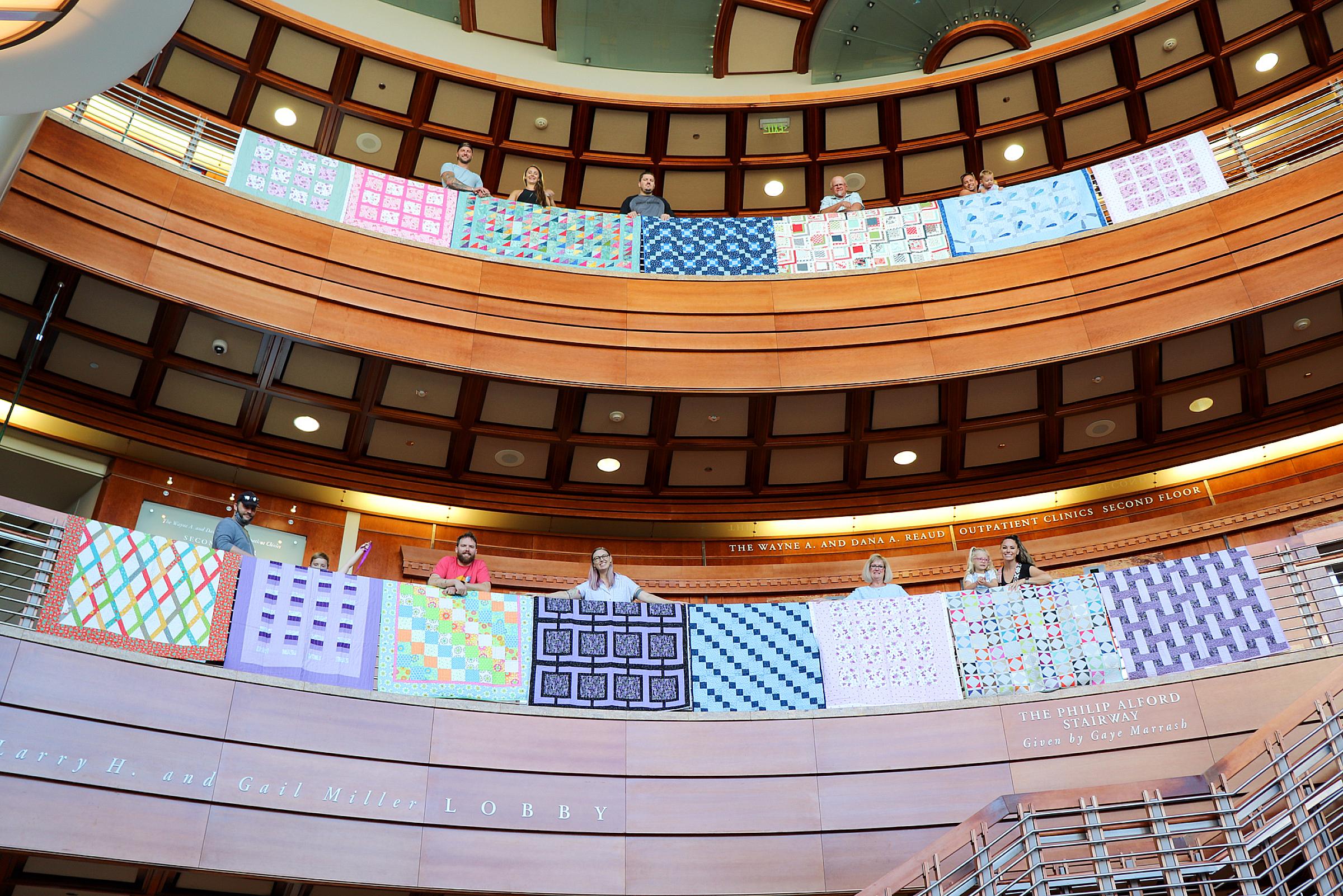 Rows of quilts hung over the railing of the second and third floors surrounding the Huntsman Cancer Institute lobby atrium