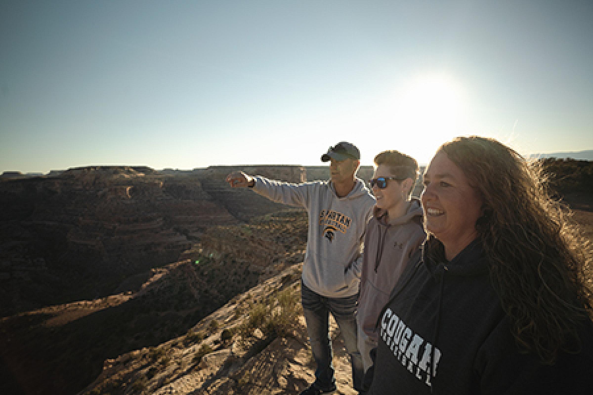 Erin Hurst and her parents standing on the edge of a cliff