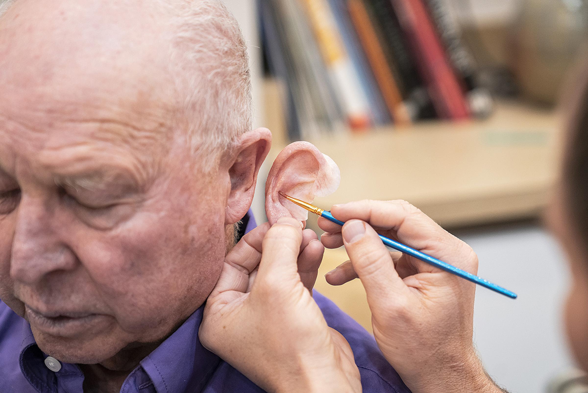 Paul Tanner matching an ear prosthetic to a patient's real ear