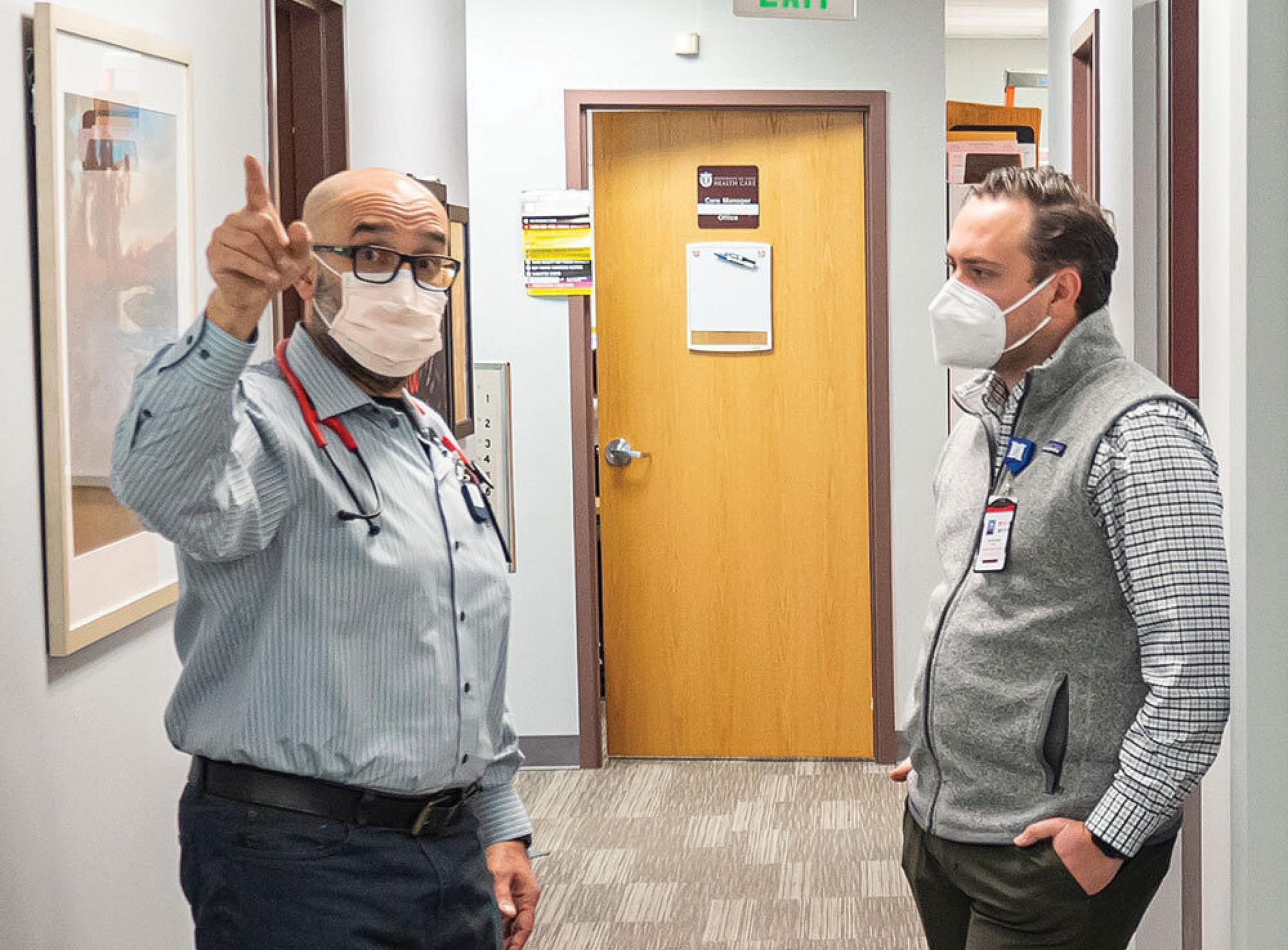Huntsman Cancer Institute community health educator Nathaniel Ferre (right) meets with Ali Salari, DO, medical director of the University of Utah Stansbury Health Center in Stansbury Park.