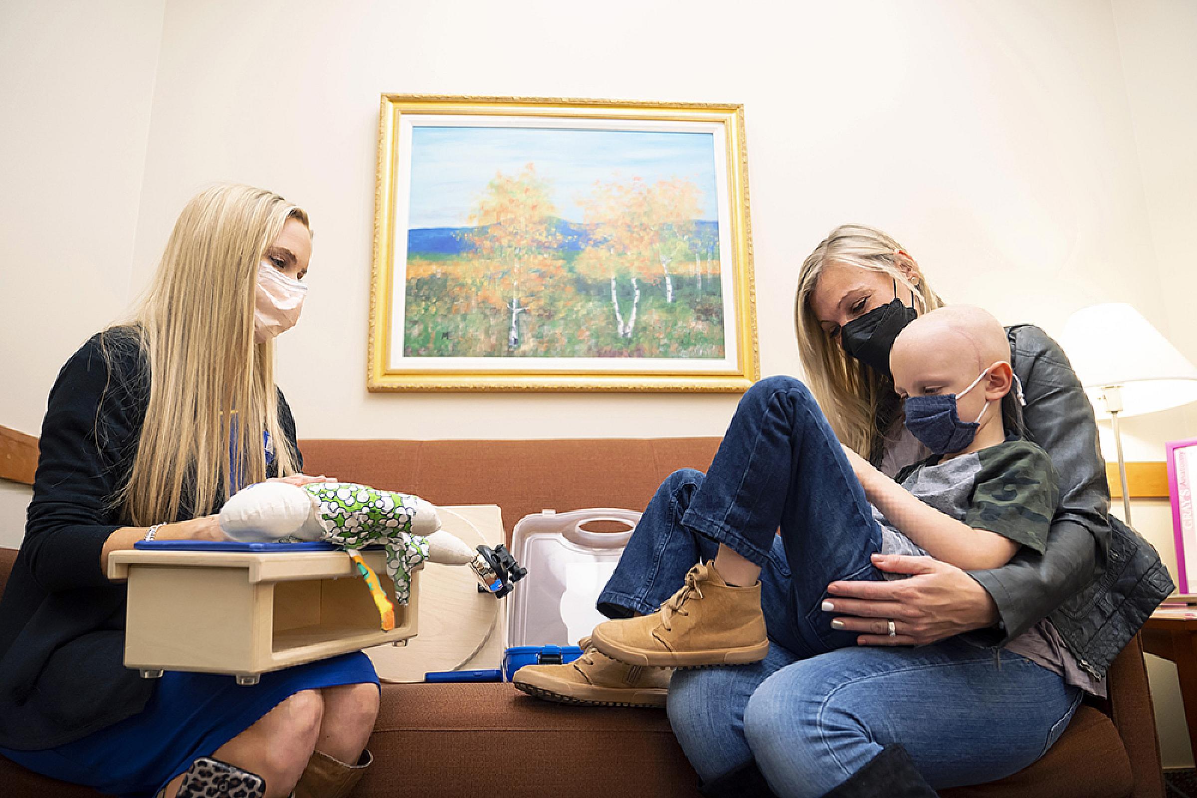 A pediatric proton therapy patient and mom meets with child life specialist prior to treatment