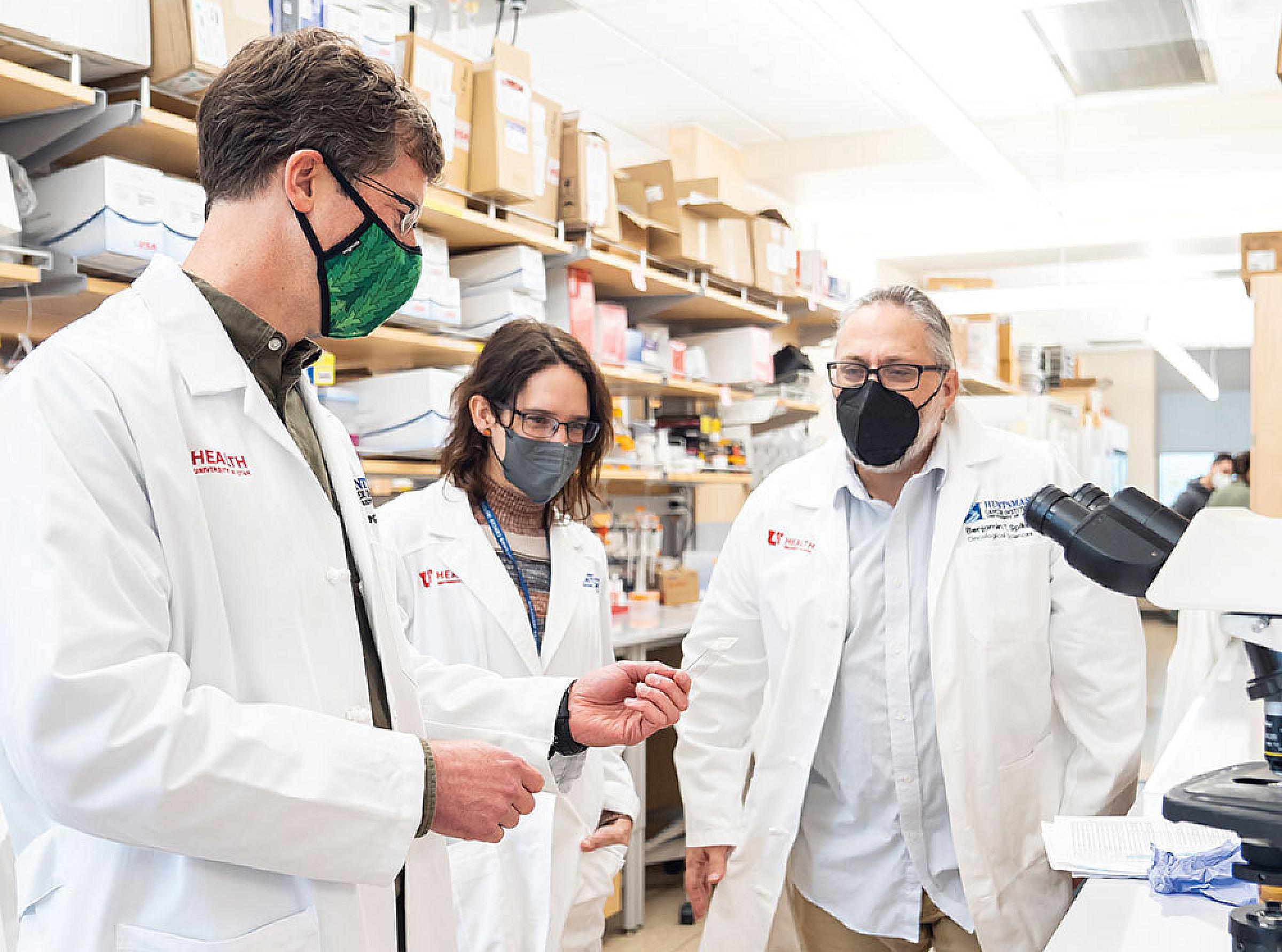 Eric Snyder, PhD, Michelle Mendoza, PhD, and Benjamin Spike, PhD, examine lung tumor cells from genetically engineered mice in the Snyder Lab.