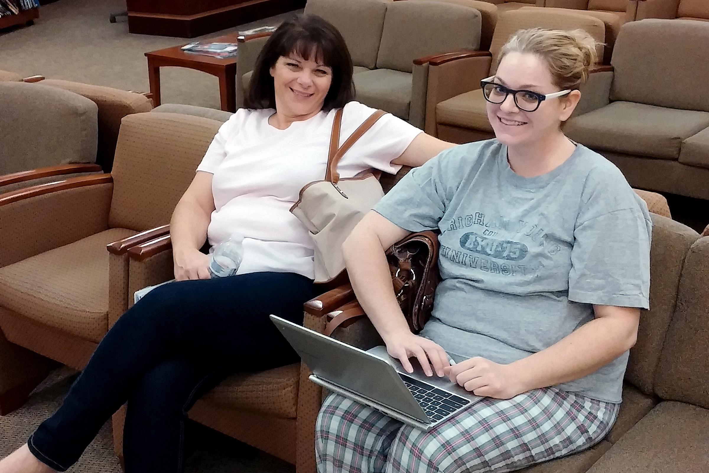 Shelli sitting in a waiting room with her mom, holding a laptop