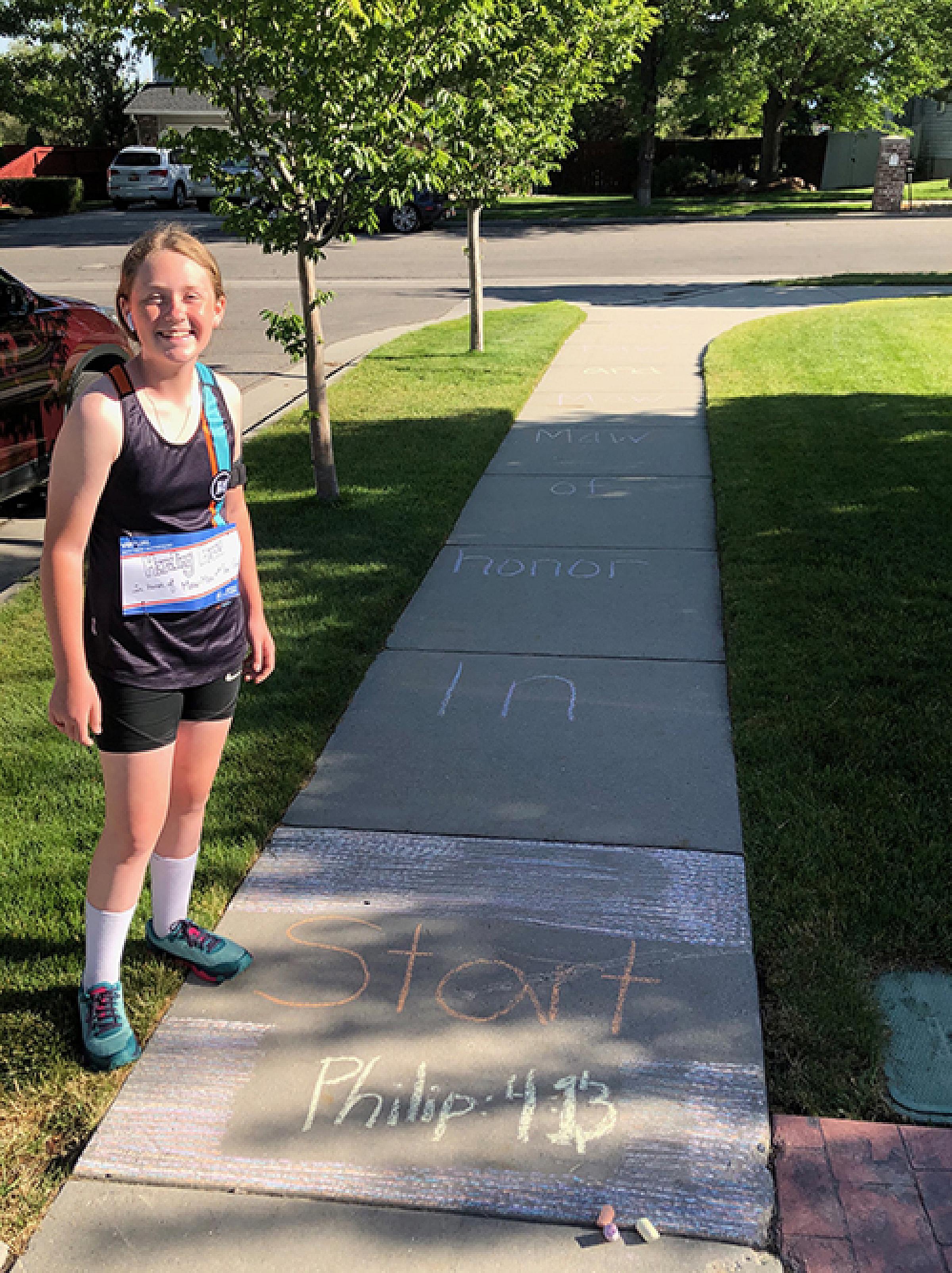 Allee Curby Standing On Sidewalk with Words Written in Chalk