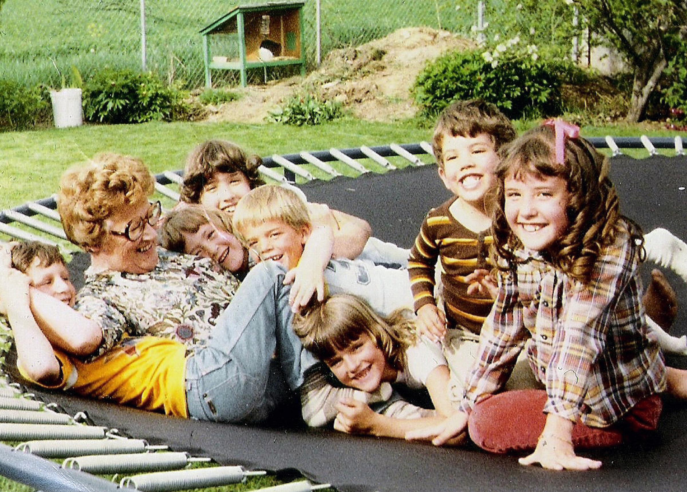 Amy Olsen's grandma with most of her grandkids playing on a trampoline
