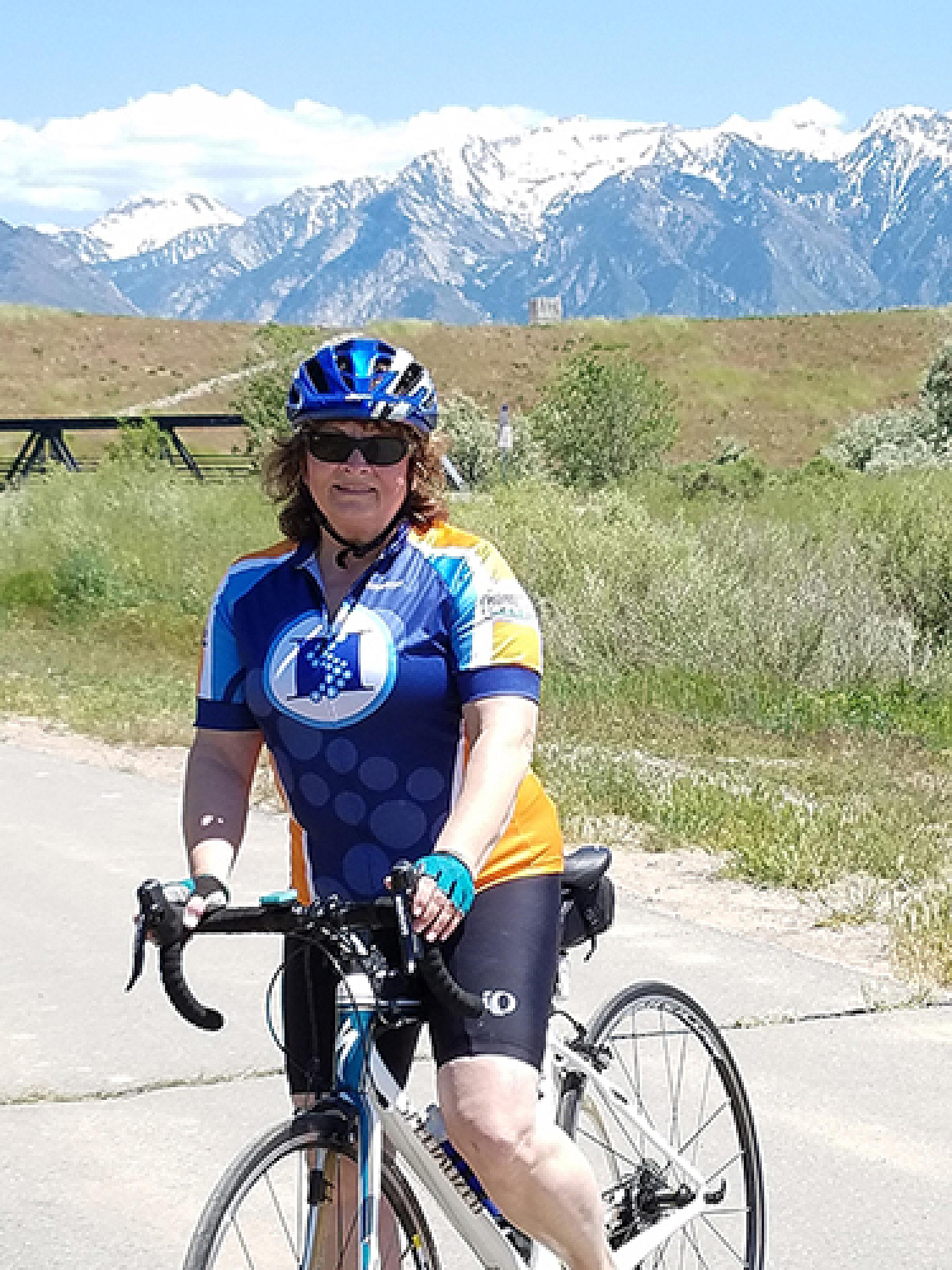 Jan Byrne on a bicycle in front of the mountians