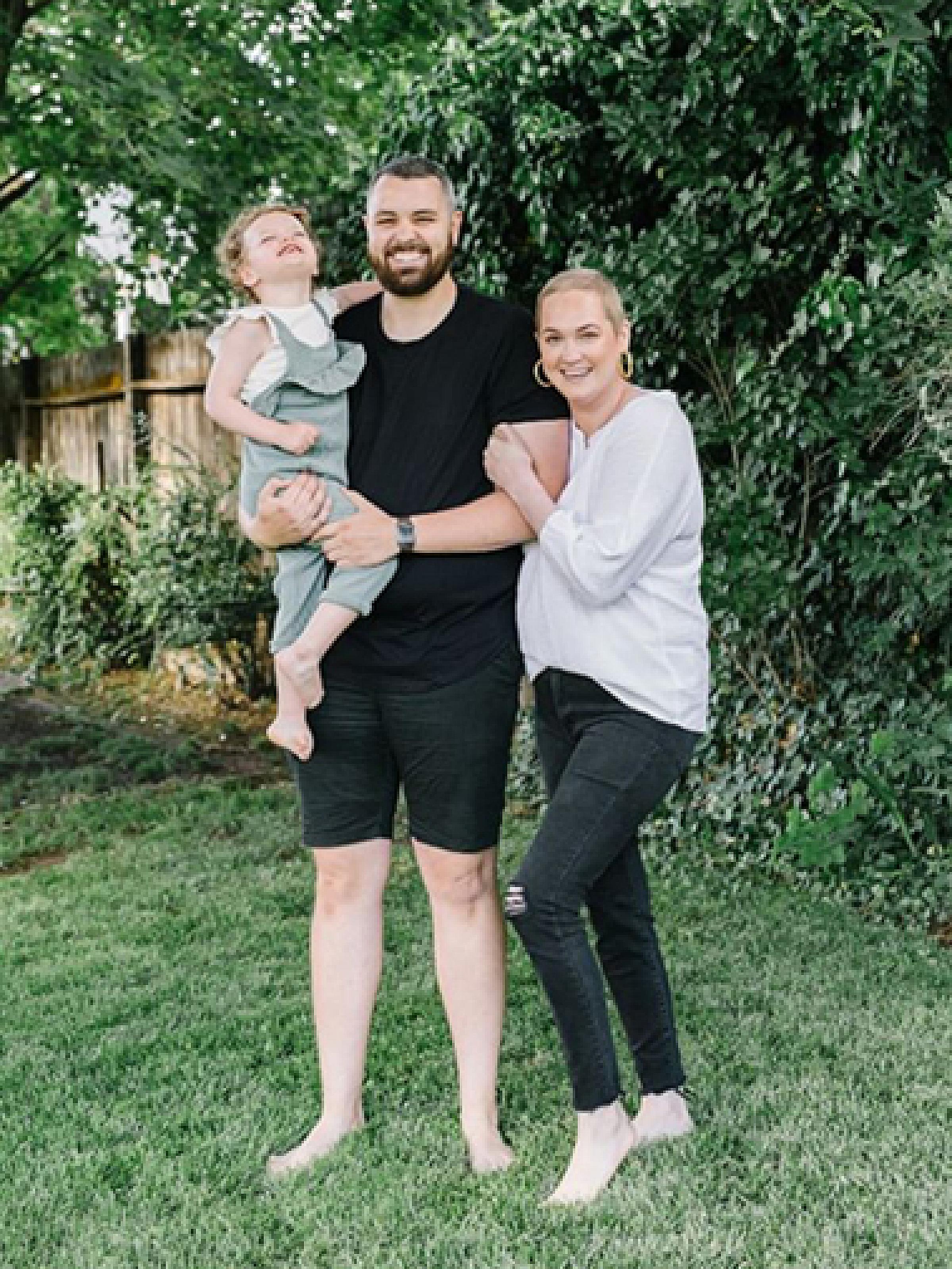 Laura Glissmeyer with her husband and daughter in their backyard