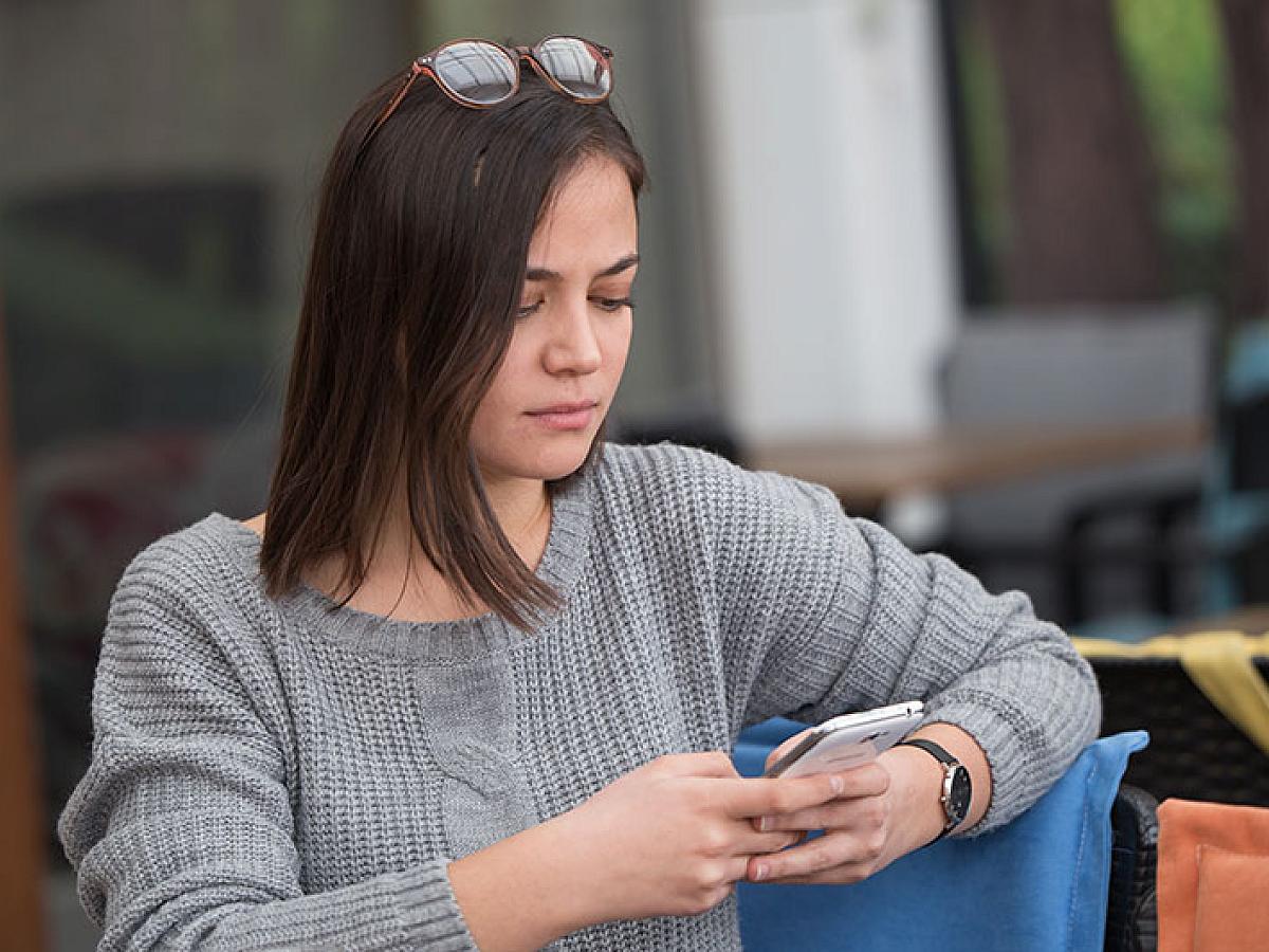 Woman looks at her phone with a serious expression