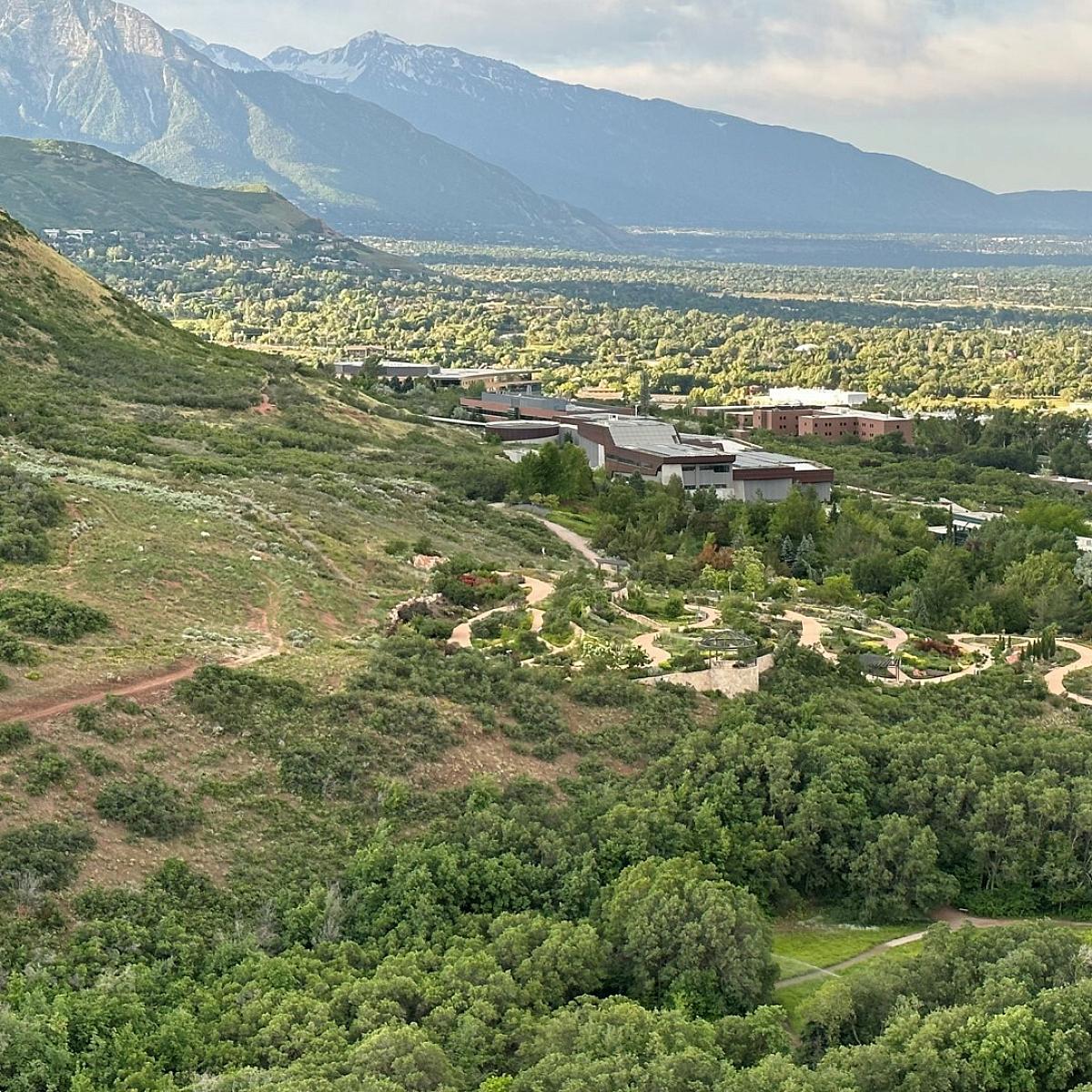 Foothills behind Huntsman Cancer Institute covered in green trees