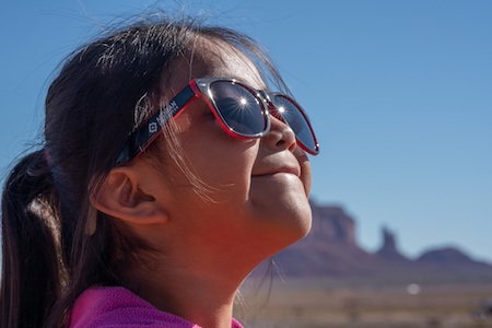 Five-year-old Shayla checks out new sunglasses from a Moran Eye Center Global Outreach Division clinic in May in Monument Valley.