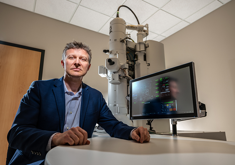 Bryan W. Jones, PhD, is pictured with his lab’s second and newest electron microscope.