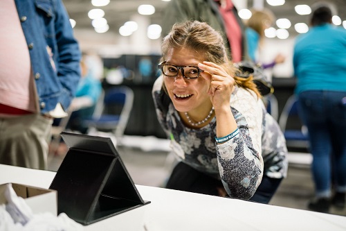 A woman tries on new eyeglasses at the 2019 annual Project Homeless Connect event in Salt Lake City.