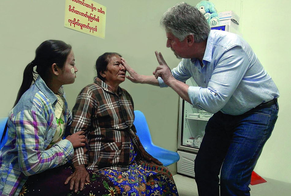 John Haines, MD, examines a patient during an outreach clinic in Myanmar in 2016.