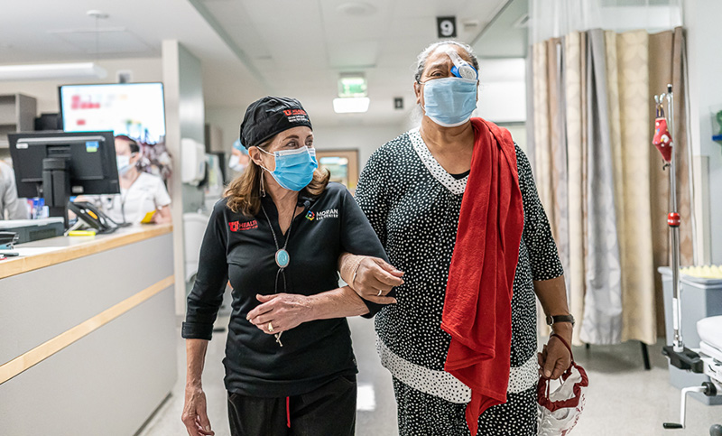 Moran outreach volunteer Ann Bagley assists a patient following cataract surgery at a recent Operation Sight Day, an annual charitable surgery event at the Moran Eye Center funded by donors.