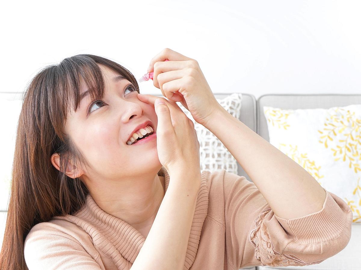 Woman putting in eyedrops.