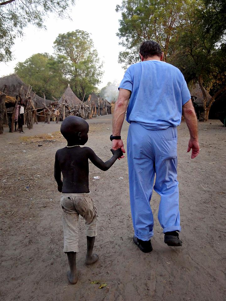 Dr. Crandall walks with a boy during an outreach trip to South Sudan.