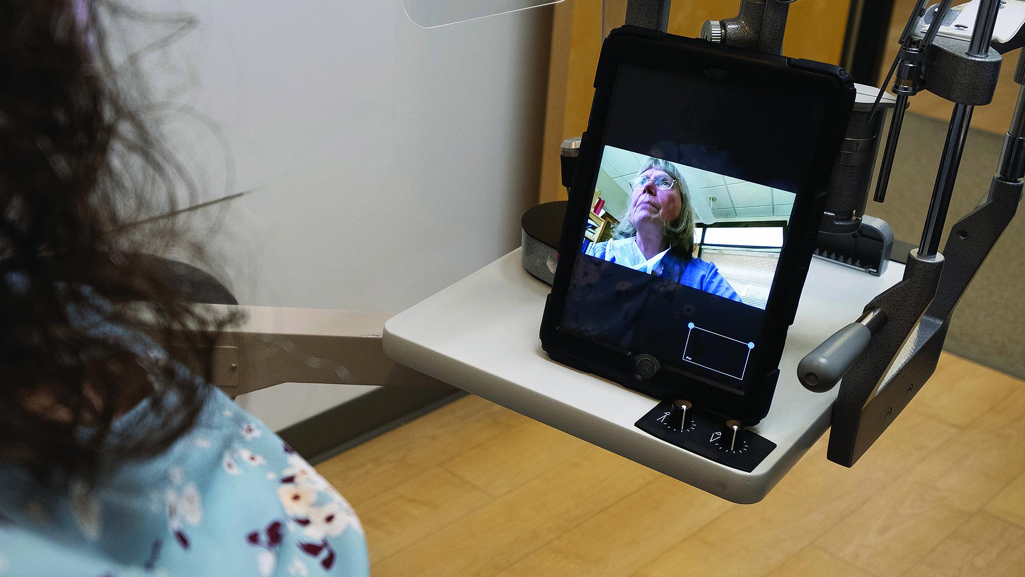 Kathleen B. Digre, MD, performs a video call with a patient from her office.