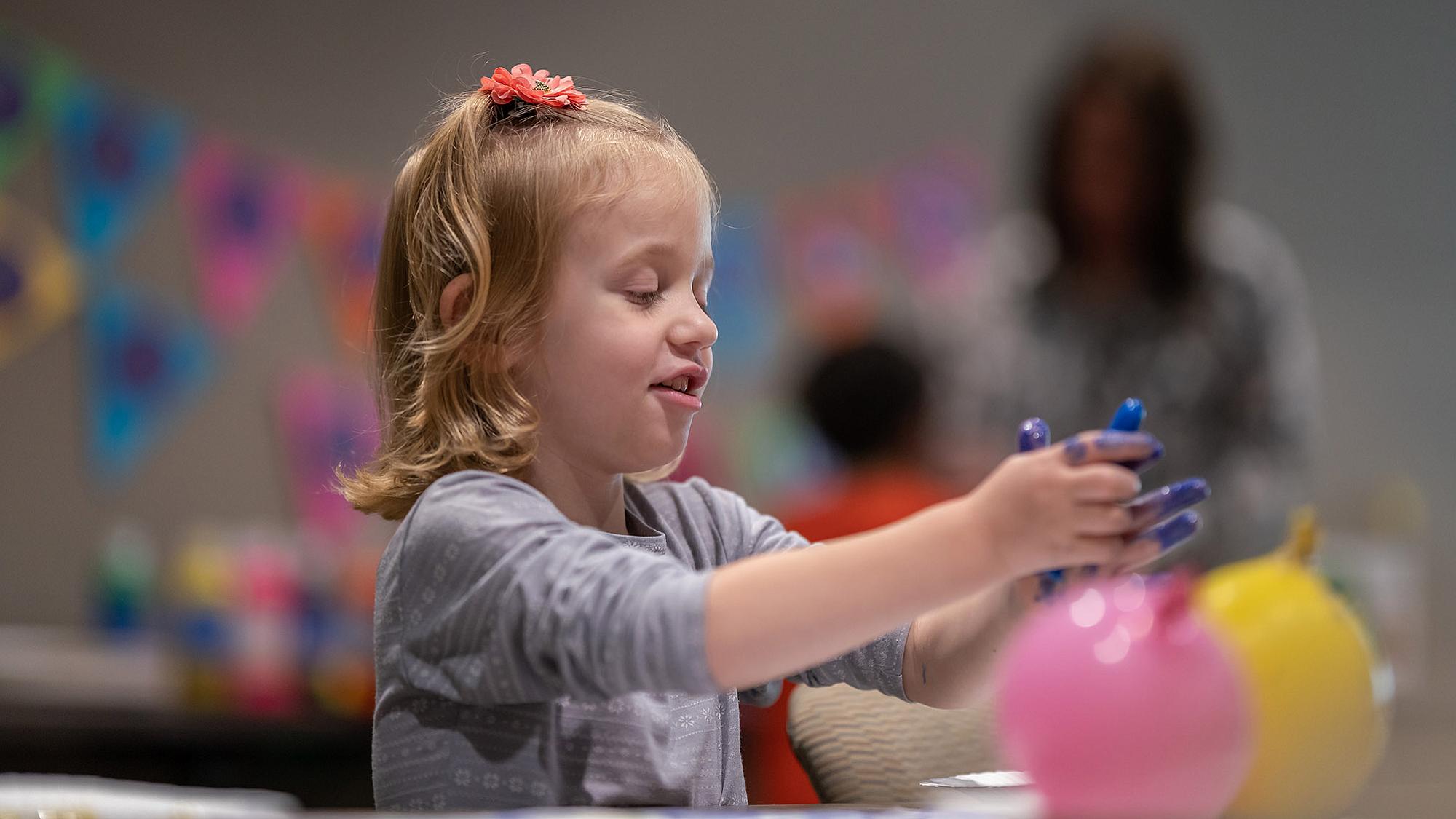Maeve combines finger-painting with balloon-painting.