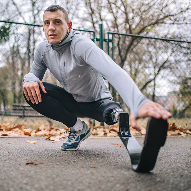 Athlete with prosthetic leg stretching before a run