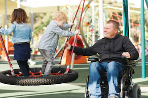 Kids in Playset with Man in Wheelchair
