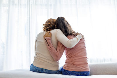 Picture of mother comforting daughter with arm around her