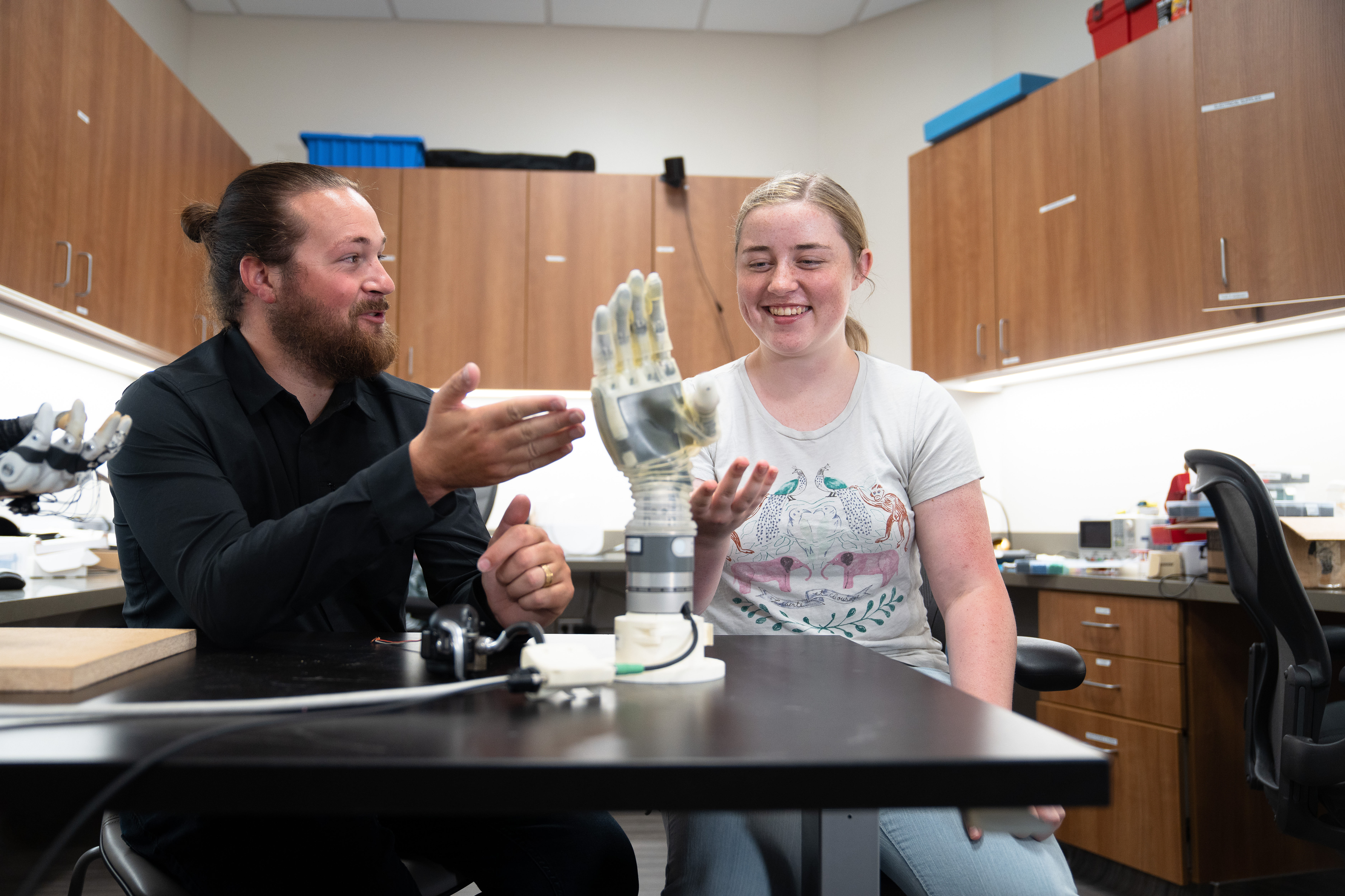 Professor Jacob George, director of the Utah NeuroRobotics Lab shows female student the Star Wars-inspired prosthetic arm.