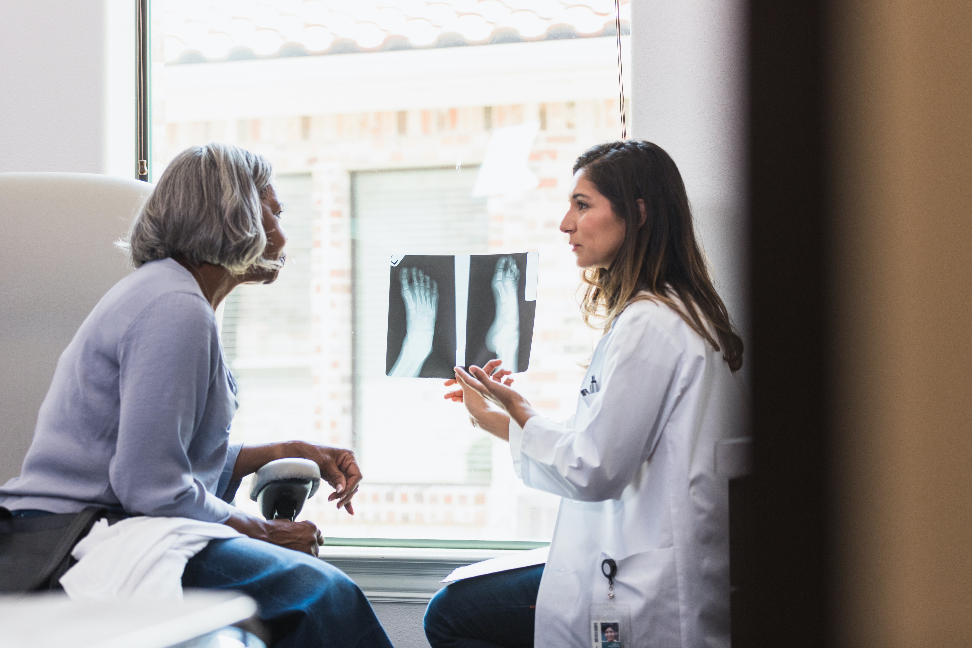 elderly woman discusses foot x-ray with doctor