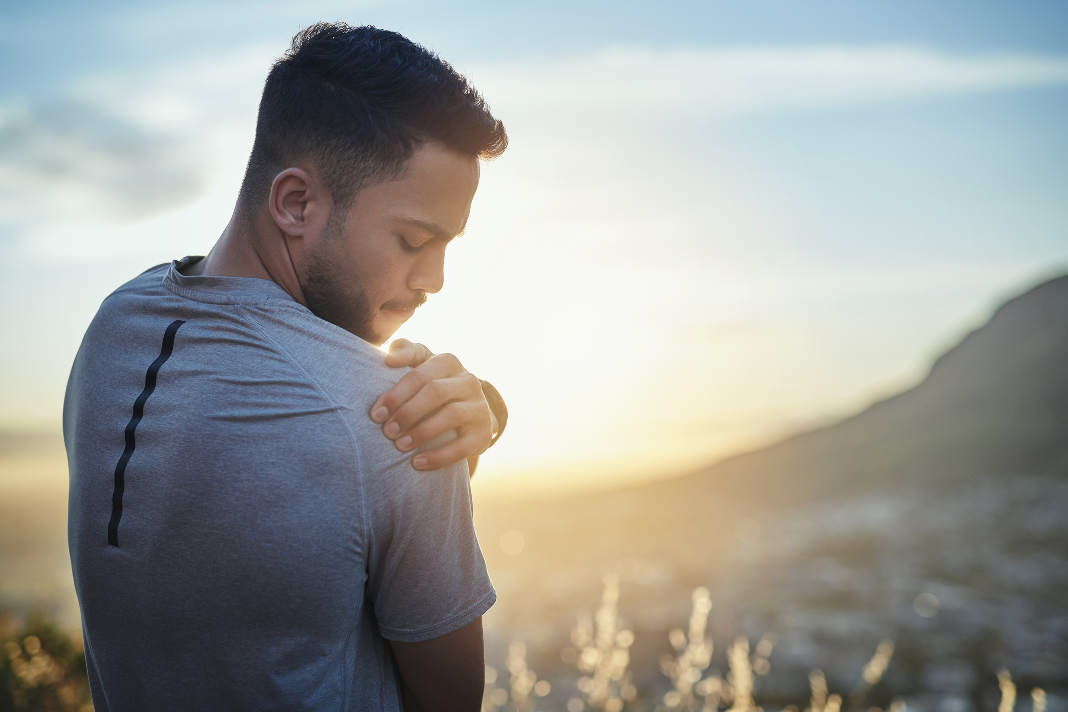 man holding shoulder in pain