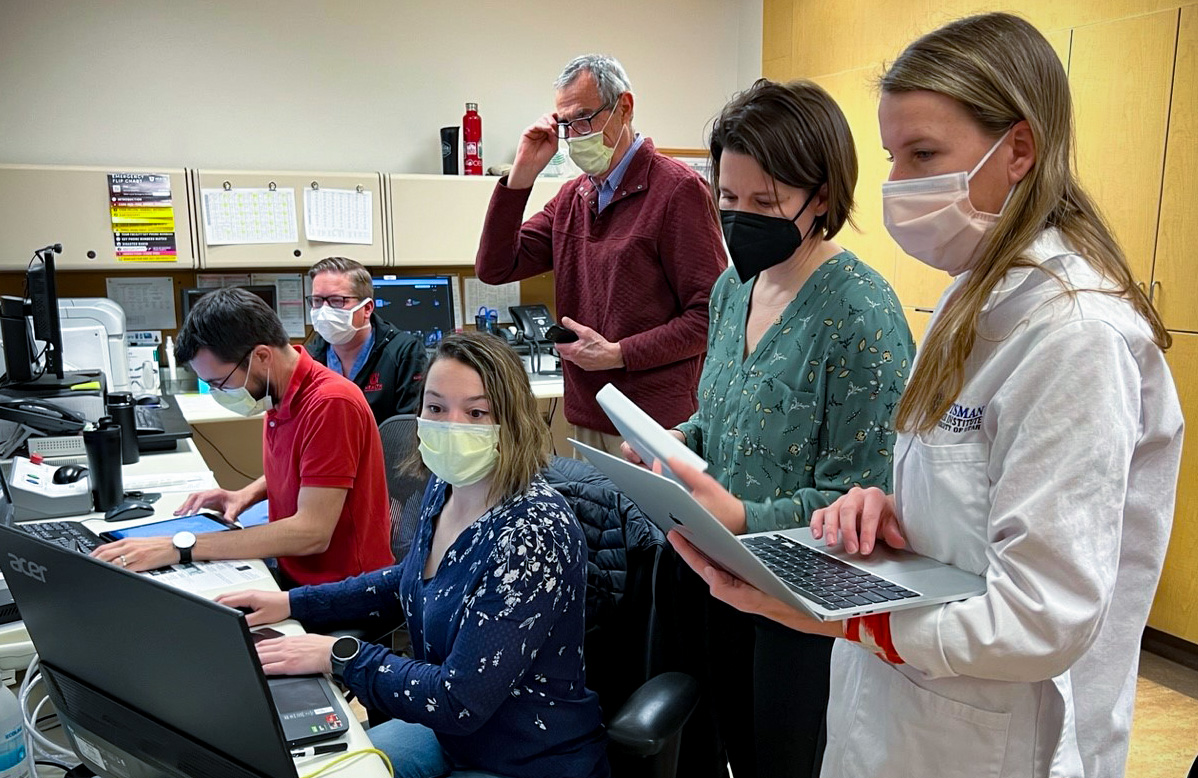 The research team in the MRI control suite: (seated, left-to-right) Henrik Odéen, PhD, Derek Maxfield, Sara Johnson, PhD, (standing, left-to-right) Dennis Parker, PhD, Allison Payne, PhD, and Nicole Winkler, MD.