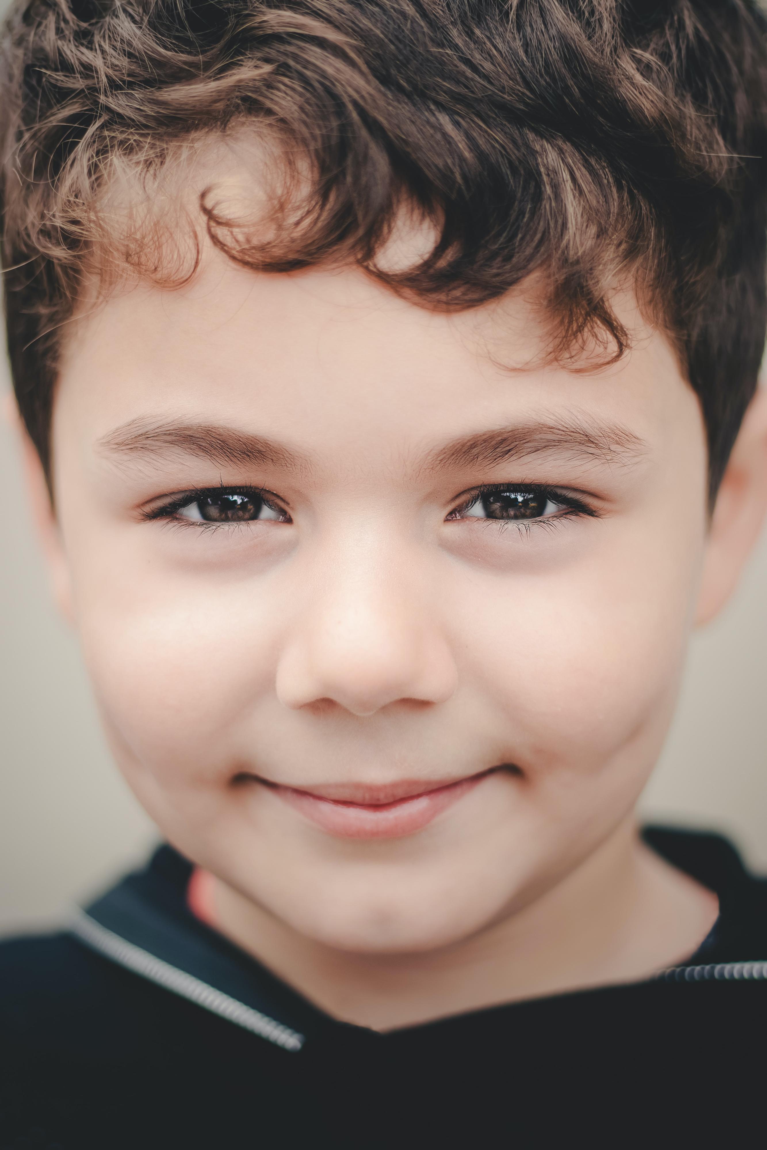 Close-up of a young boy with brown curly hair.