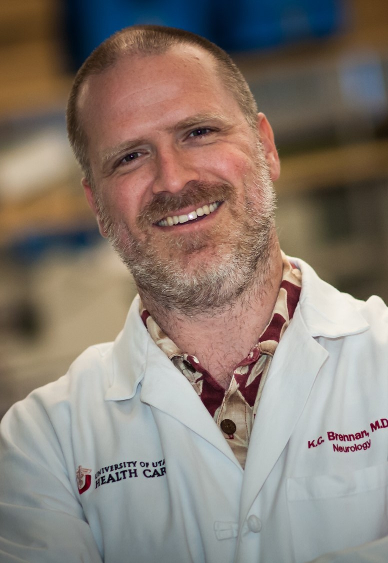 Profile photo of KC Brennan, a bearded man wearing a lab coat.