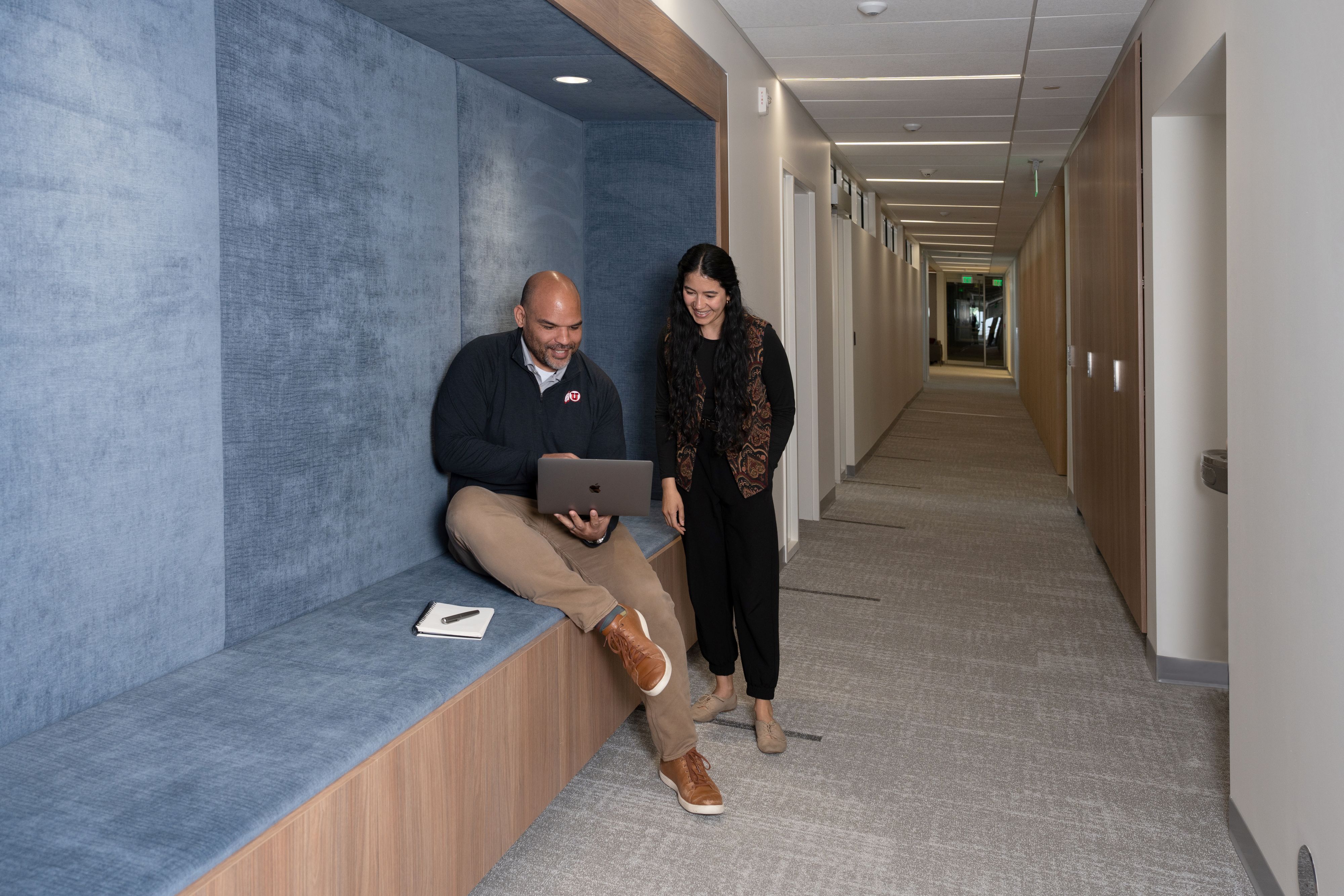 Justin Jackson discusses work with Alex Hernandez in the hallway
