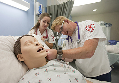 nursing students practicing on a dummy patient