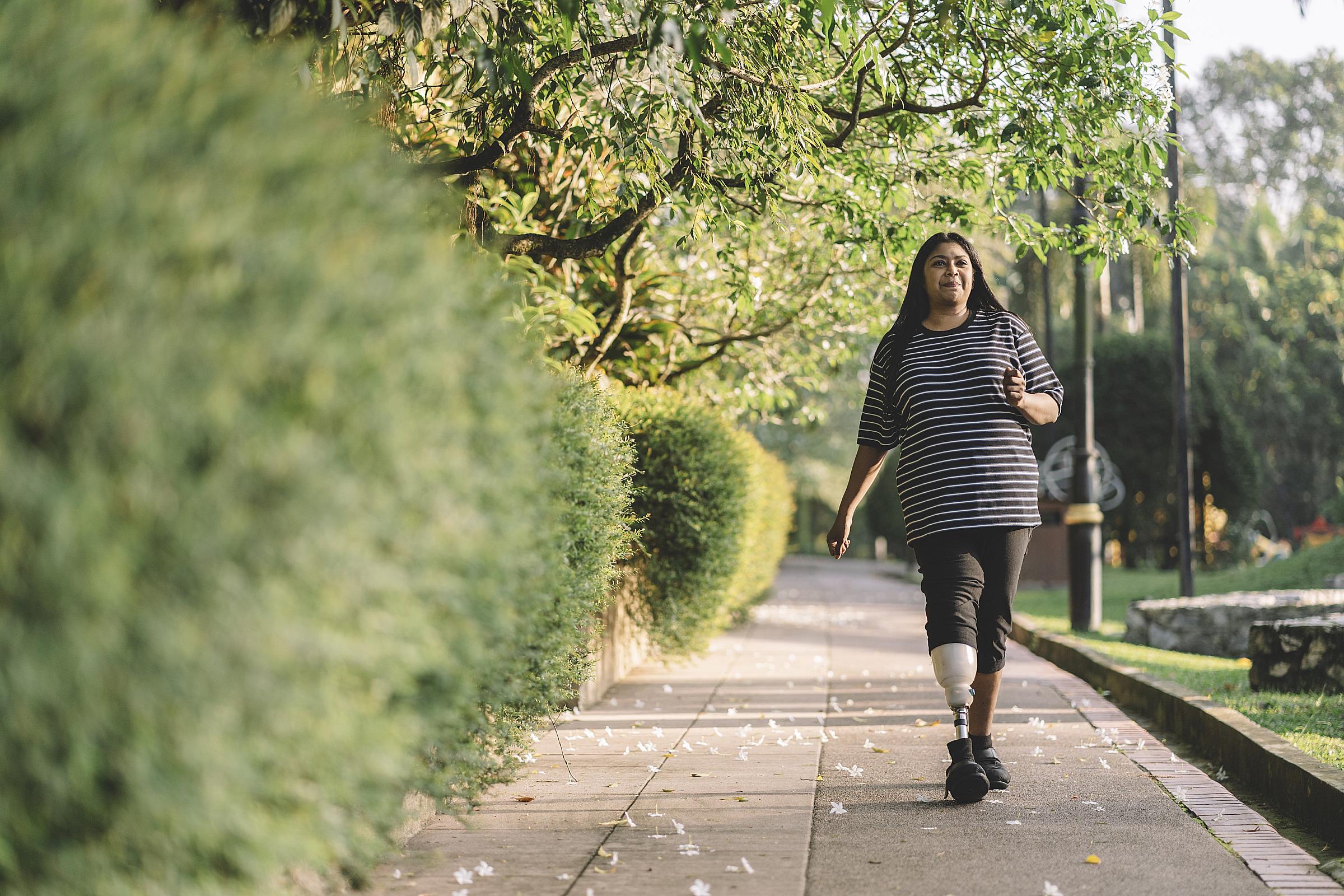 Latina woman with a prosthetic leg walks outside