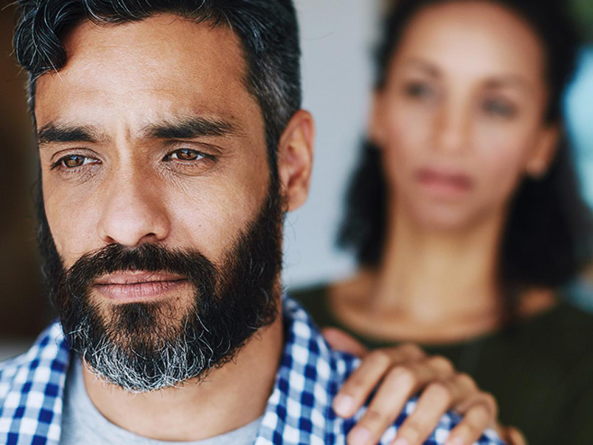 Woman with hand on shoulder of depressed man