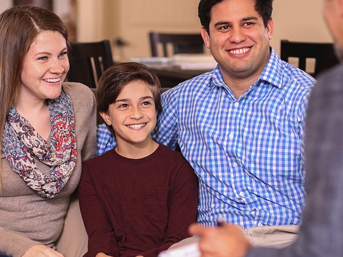 family smiling together talking to therapist