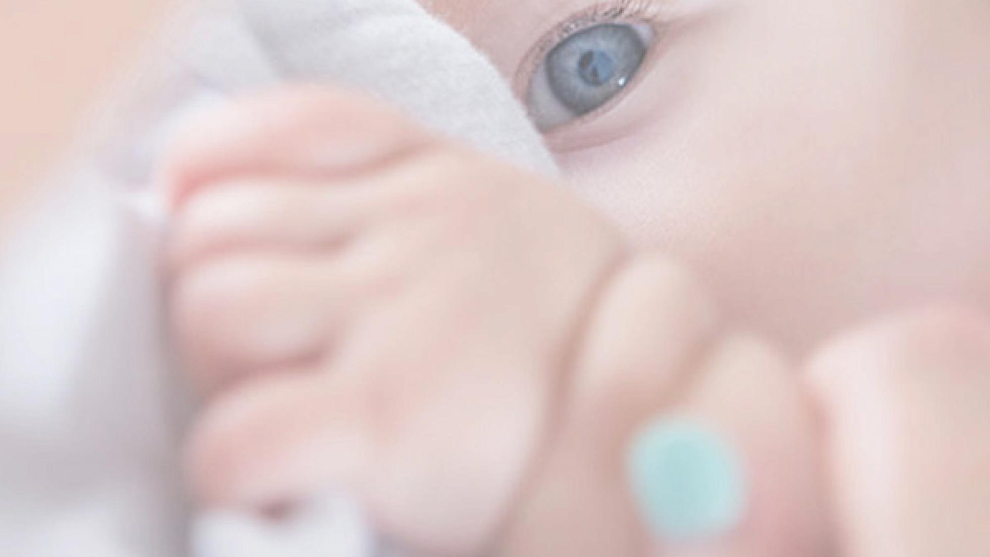 Close up of a baby's eye and hand